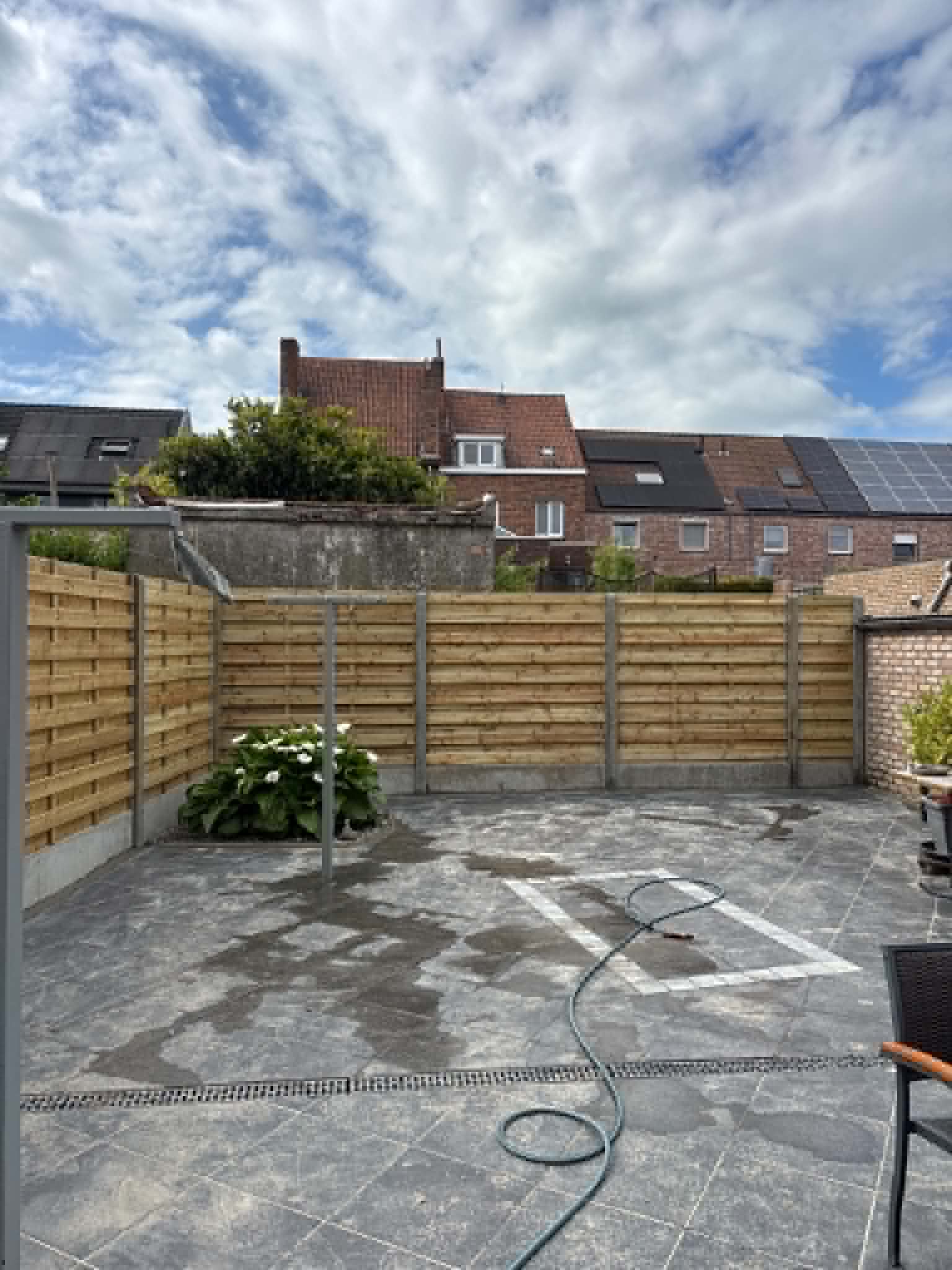 Houten schermen met betonpalen rond een terras