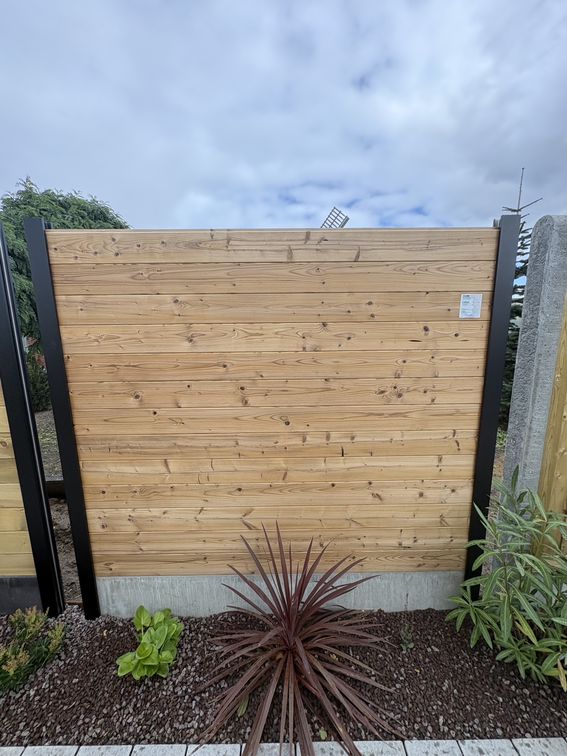 Thermowood tand-en-groef met aluminium palen en betonnen onderplaat in het toonpark van Watty