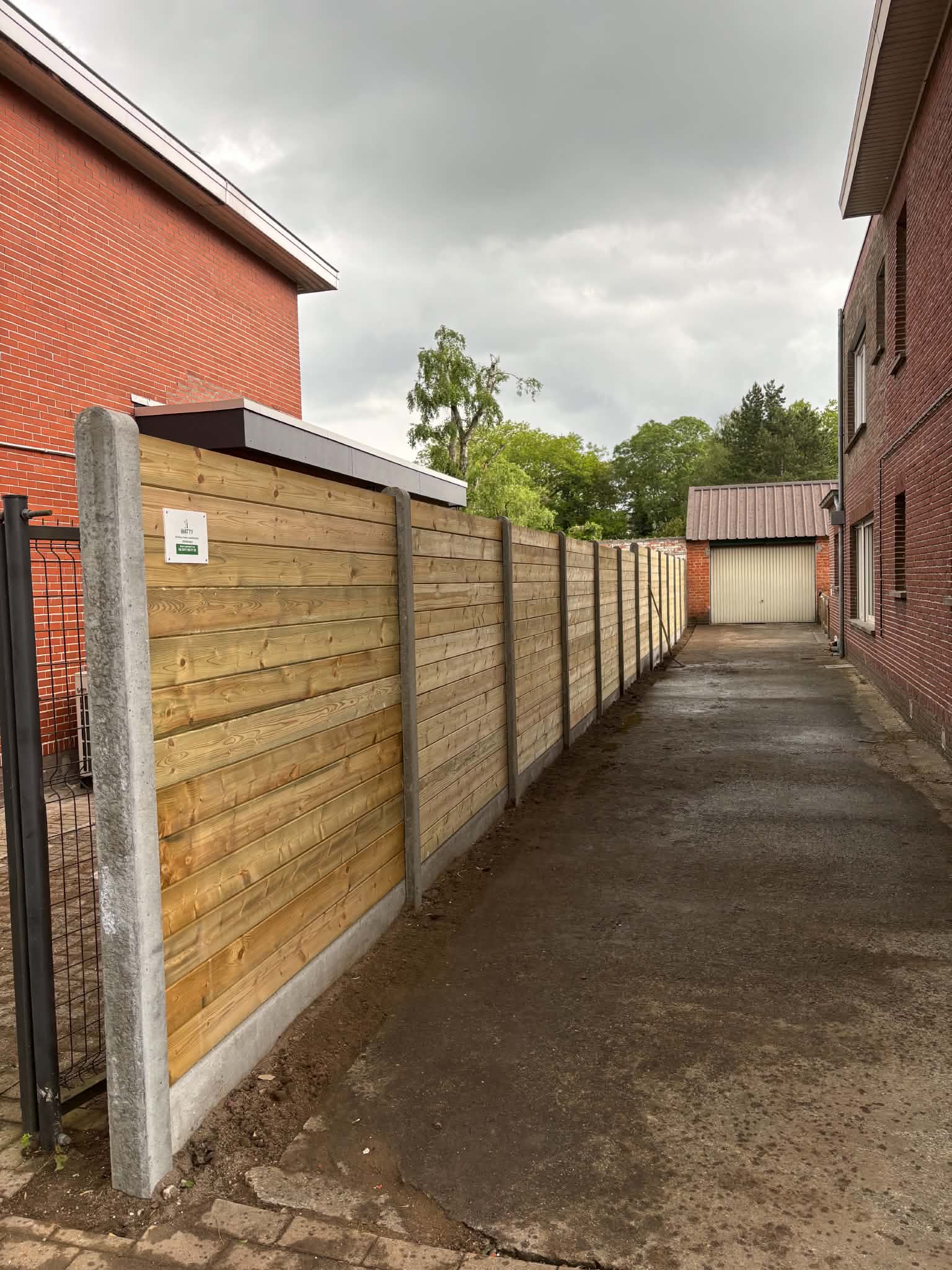 Tand en groefplanken met betonpalen geplaatst door Watty Afsluitingen in knesselare