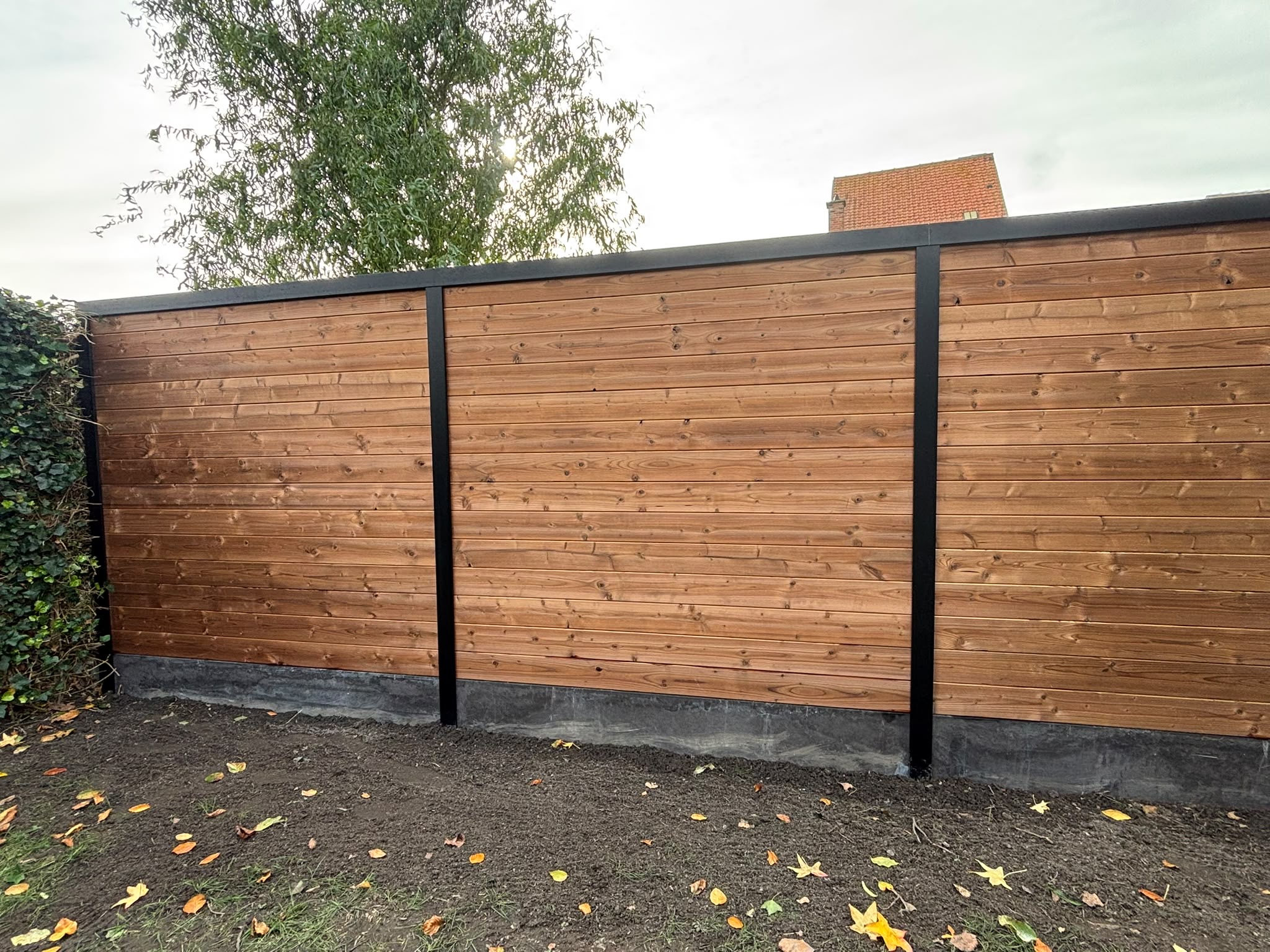 Thermowood tand en groef met alu palen geplaatst door Watty Afsluitingen in Bredene