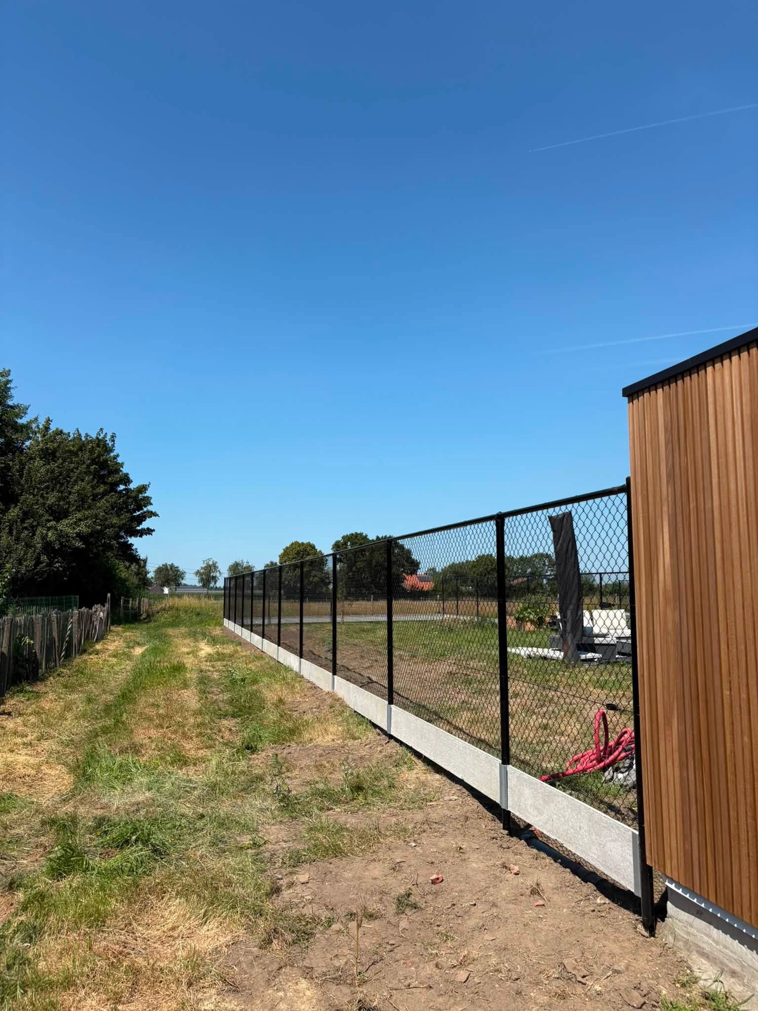 Draadafsluiting 180cm + betonplaat geplaatst door Watty Afsluitingen in Torhout