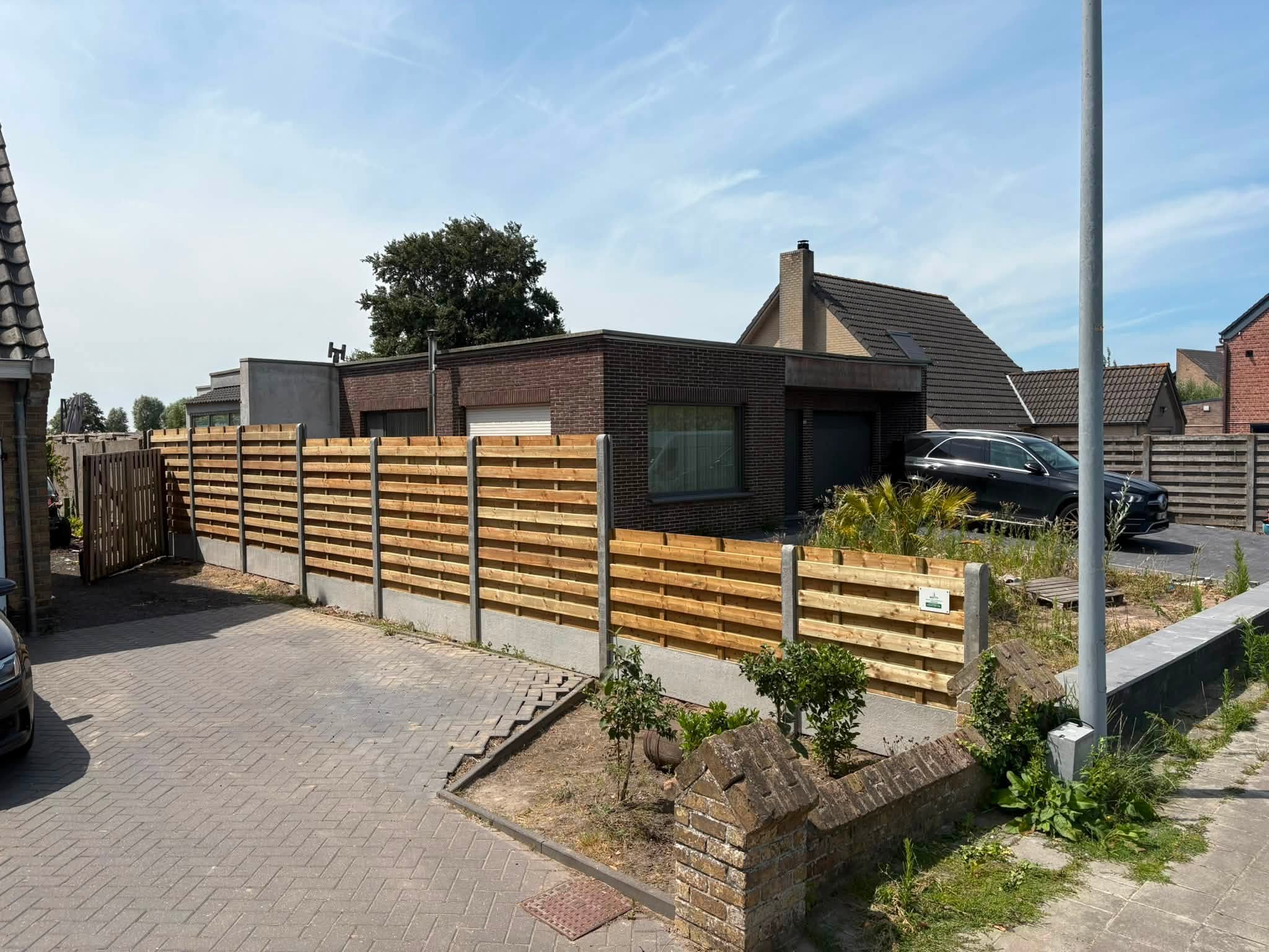 houtenscherm afsluiting op verschillende niveaus geplaatst door Watty Afsluitingen in Zandvoorde