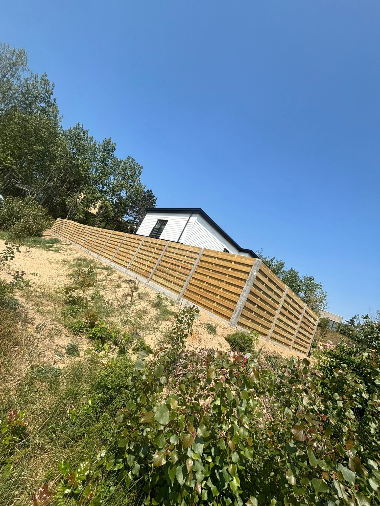 plaatsen van houten scherm afsluiting in de duinen met extra fundering geplaatst door Watty Afsluitingen in Koksijde
