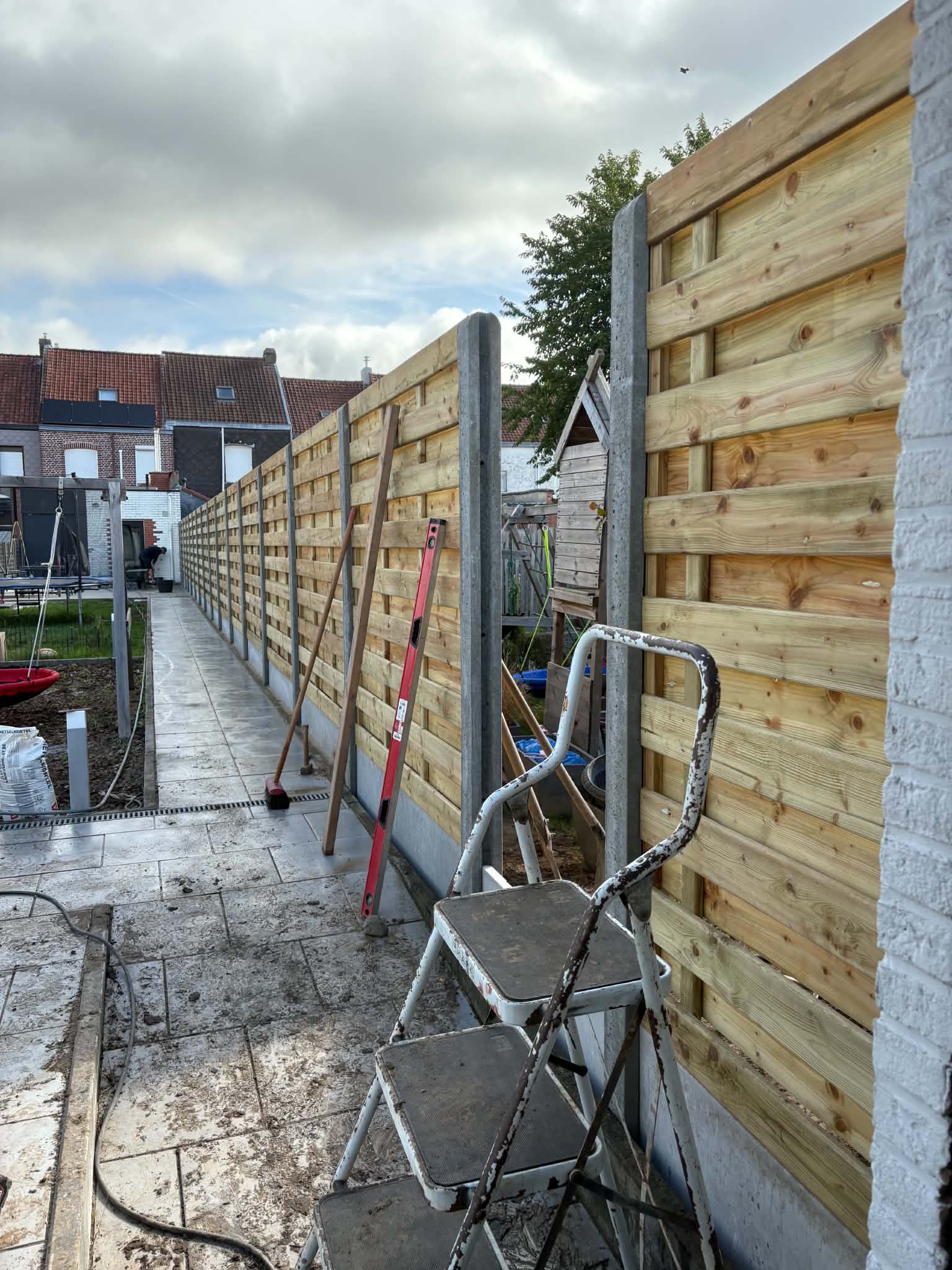 Houtenscherm afsluiting met nodige afwerking tegen onkruid geplaatst door Watty Afsluitingen in Wervik