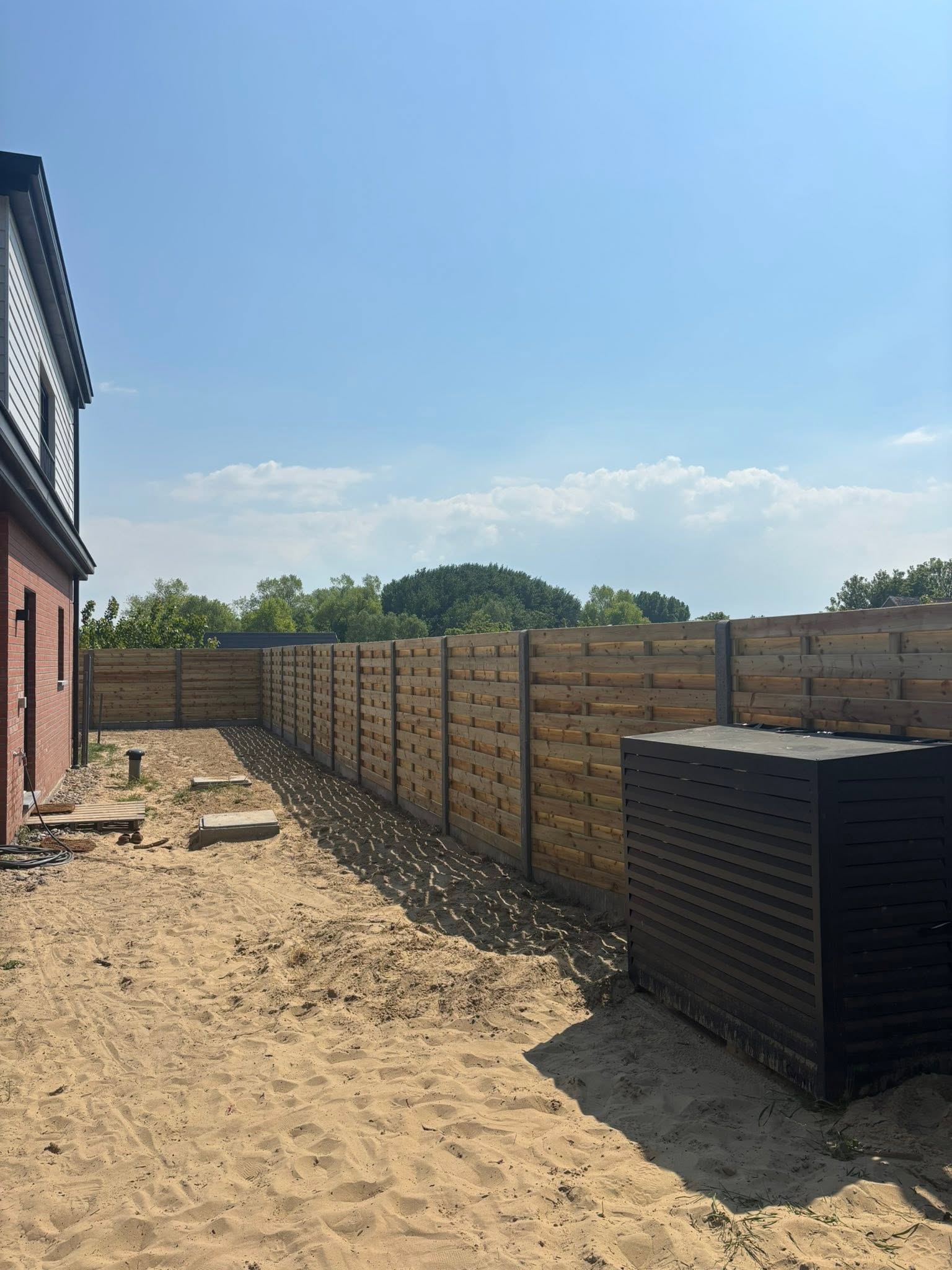plaatsen van houten scherm afsluiting in de duinen met extra fundering geplaatst door Watty Afsluitingen in Koksijde