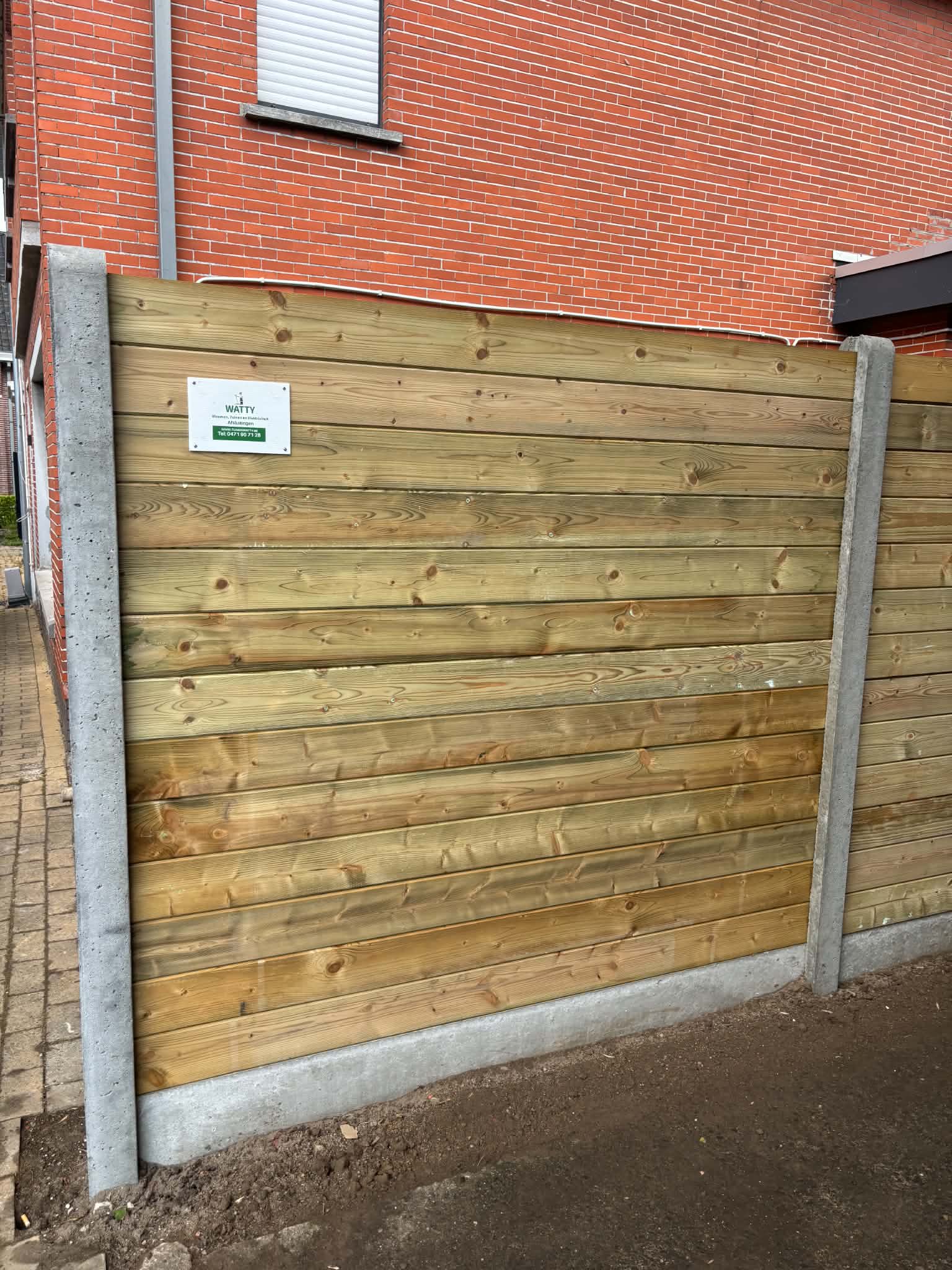 Tand en groefplanken met betonpalen geplaatst door Watty Afsluitingen in knesselare