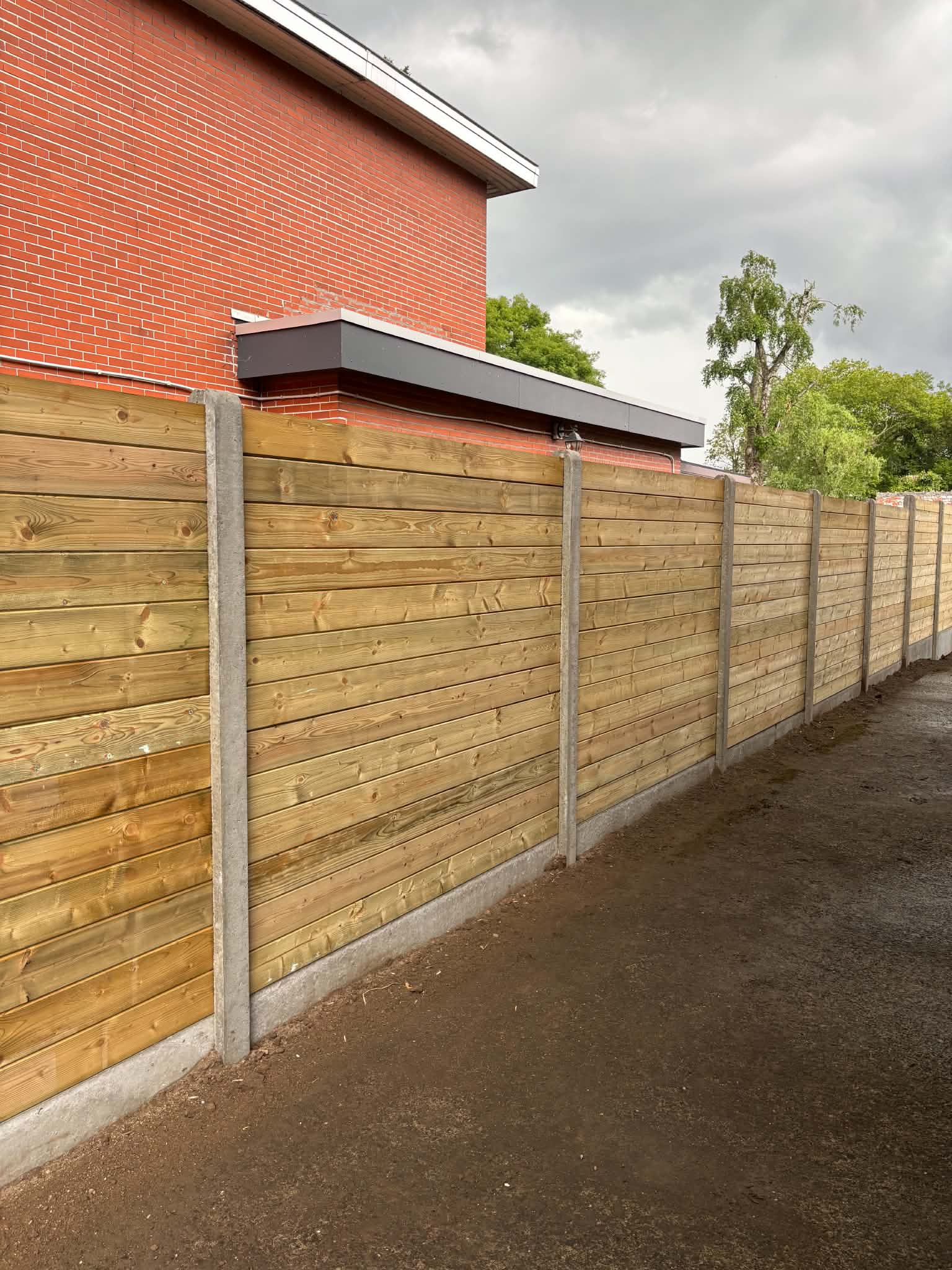 Tand en groefplanken met betonpalen geplaatst door Watty Afsluitingen in knesselare