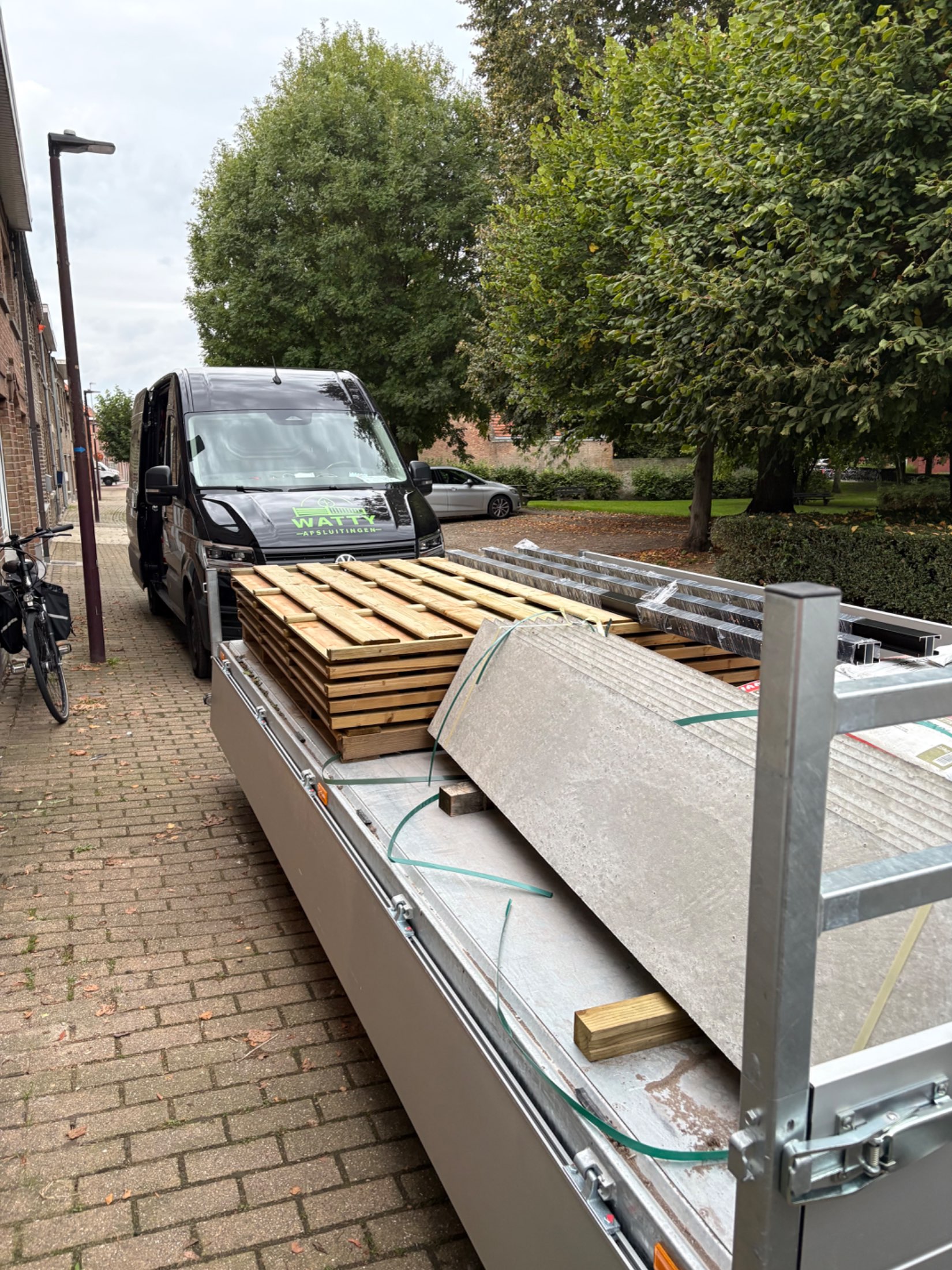Houten scherm afsluiting met aluminium palen geplaatst door Watty Afsluitingen in Oudenburg