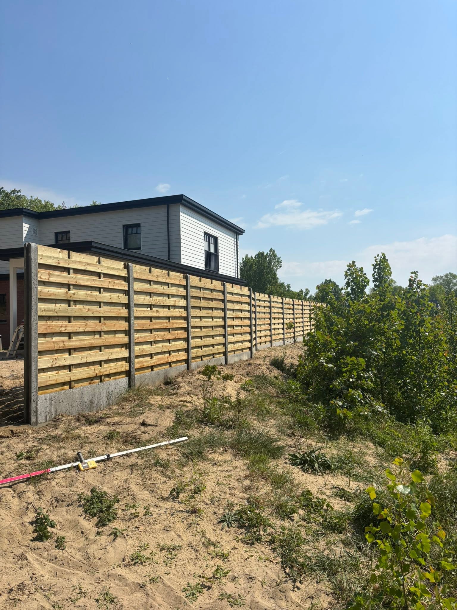 plaatsen van houten scherm afsluiting in de duinen met extra fundering geplaatst door Watty Afsluitingen in Koksijde